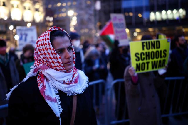 A woman looks on as demonstrators gather to protest against US military action in Iran in the Manhattan borough of New York City on April 7, 2026. US President Donald Trump said on April 7 he agreed to suspend bombing of Iran for two weeks as part of a ceasefire deal if Tehran completely reopens the vital Strait of Hormuz. The announcement came after Pakistan made a last-minute proposal to avert massive US attacks on Iran, with Trump warning a "whole civilization will die tonight" unless a deal was agreed. (Photo by CHARLY TRIBALLEAU / AFP)