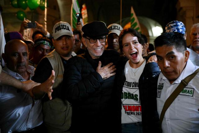Peru's presidential candidate Ricardo Belmont (C), for the Civico Obras party, greets supporters accompanied by his daughter Kristen Belmont upon arrival at his closing campaign rally at San Martin Square in Lima on April 7, 2026. Peru will hold presidential elections on April 12. (Photo by Luis ROBAYO / AFP)