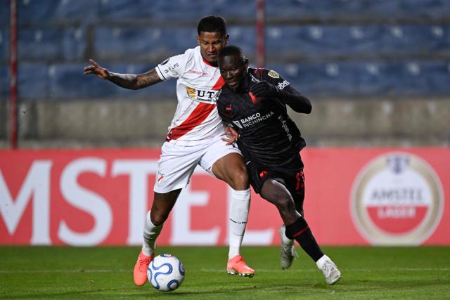 Always Ready's Colombian defender #21 Alex Rambal and Liga de Quito's forward #13 Janner Corozo fight for the ball during the Copa Libertadores group stage football match between Bolivia's Always Ready and Ecuador's Liga de Quito at the Municipal de Villa Ingenio stadium in El Alto, La Paz department, Bolivia, on April 7, 2026. (Photo by AIZAR RALDES / AFP)