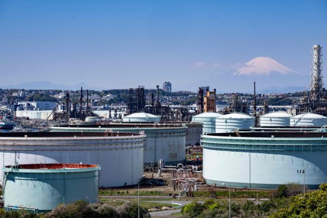 Storage tanks are seen at an oil refinery as Mount Fuji looms in the background in Yokohama, Kanagawa prefecture on April 8, 2026. (Photo by Yuichi YAMAZAKI / AFP)