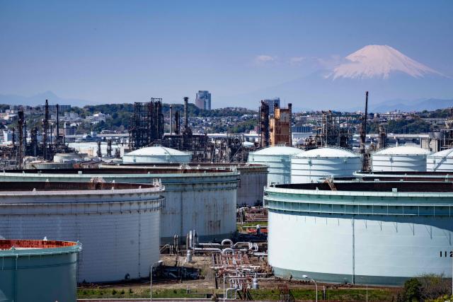 Storage tanks are seen at an oil refinery as Mount Fuji looms in the background in Yokohama, Kanagawa prefecture on April 8, 2026. (Photo by Yuichi YAMAZAKI / AFP)