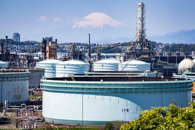 Storage tanks are seen at an oil refinery as Mount Fuji looms in the background in Yokohama, Kanagawa prefecture on April 8, 2026. (Photo by Yuichi YAMAZAKI / AFP)