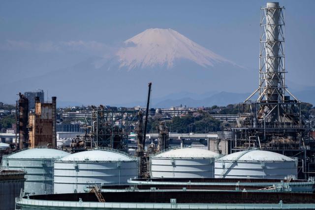 Storage tanks are seen at an oil refinery as Mount Fuji looms in the background in Yokohama, Kanagawa prefecture on April 8, 2026. (Photo by Yuichi YAMAZAKI / AFP)