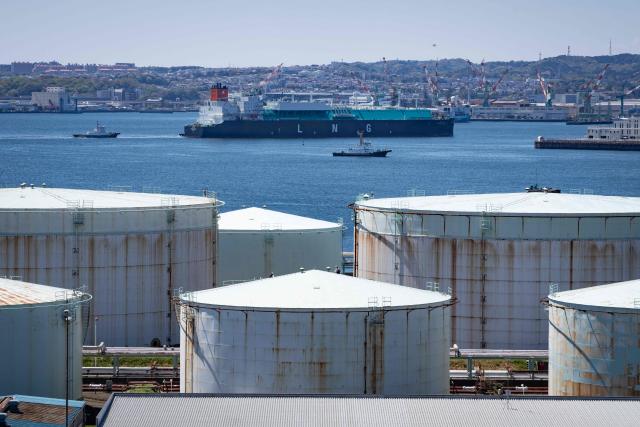 A liquefied natural gas (LNG) tanker sails past oil storage tanks at an oil refinery in Yokohama, Kanagawa prefecture on April 8, 2026. (Photo by Yuichi YAMAZAKI / AFP)