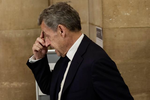 France's former President Nicolas Sarkozy gestures as he arrives for his appeal trial over charges he sought Libyan financing for his 2007 election, at the Palais de Justice courthouse in Paris on April 8, 2026. The Paris Criminal Court in September 2025 convicted Sarkozy of criminal conspiracy and handed him a 5-year prison sentence over what it said was a scheme to acquire funding from Muammar Gaddafi's Libya for his 2007 presidential run that saw him elected. The right-wing politician -- who has denied any wrongdoing -- entered a Paris jail in October 2025, serving 20 days before he was released under judicial supervision. (Photo by STEPHANE DE SAKUTIN / AFP)