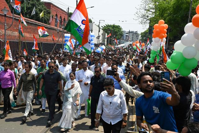 Chief Minister of West Bengal and Chairperson of All India Trinamool Congress, Mamata Banerjee greets her supporters as she arrives to file her nomination papers for the upcoming legislative assembly elections in Kolkata on April 8, 2026. (Photo by Dibyangshu SARKAR / AFP)