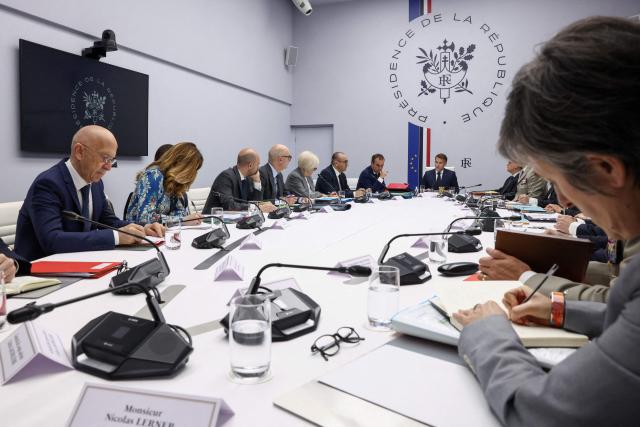 French President Emmanuel Macron (C) chairs a meeting of France's defence and security council following the Iran war ceasefire announcement and to address the return of Cecile Kohler and Jacques Paris, two French nationals freed by Iran after three and a half years in detention, at the Elysee Palace in Paris, on April 8, 2026. (Photo by Tom Nicholson / POOL / AFP)