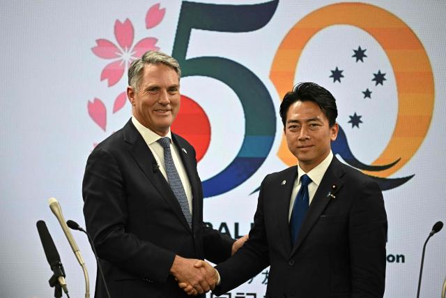 Australia's Defence Minister Richard Marles (L) and Japan's Defence Minister Shinjiro Koizumi shake hands during a joint press conference at the Defence Ministry in Tokyo on April 8, 2026. (Photo by Philip FONG / AFP)