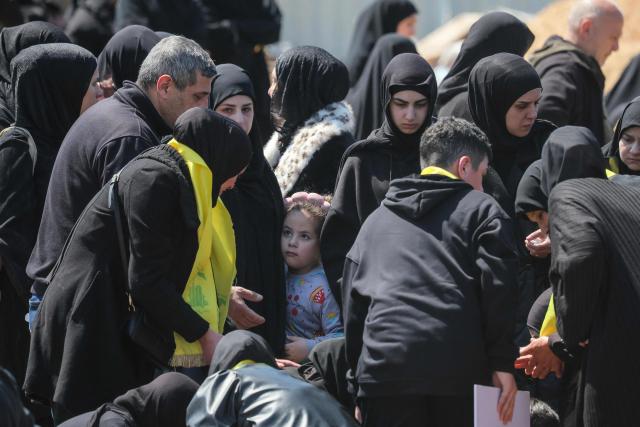 A girld looks on as mourners gather for the funeral of a Hezbollah fighter at a temporary graveyard in Choueifat, south of Beirut, on April 8, 2026. Israel's military said on April 8, its forces would continue their campaign against Hezbollah fighters, claiming the ceasefire with Iran does not apply to Lebanon. (Photo by ibrahim AMRO / AFP)