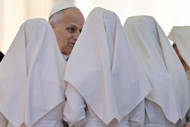 Pope Leo XIV speaks with nuns at the end of the weekly general audience at St Peter's Square in The Vatican on April 8, 2026. (Photo by Tiziana FABI / AFP)