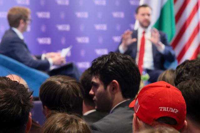 A member of the audience wears a cap in support of US President Donald Trump as US Vice President JD Vance delivers remarks at Mathias Corvinus Collegium in Budapest on April 8, 2026, on the second day of his visit to Hungary. (Photo by Jonathan Ernst / POOL / AFP)