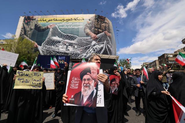 Iranians hold portraits of the country’s slain supreme leader Ayatollah Ali Khamenei as they gather in Tehran's Revolution Square after the United States and Iran agreed to a two-week ceasefire, on April 8, 2026. The United States and Iran agreed to a two-week ceasefire barely an hour before the US president's April 8 deadline to obliterate the country, triggering global relief alongside apprehension. (Photo by ATTA KENARE / AFP) / 