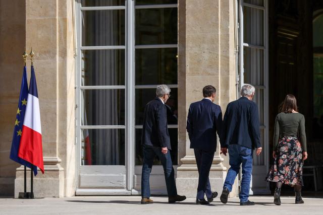 French President Emmanuel Macron (2L), flanked by French ambassador to Iran Pierre Cochard (L), welcomes French national Jacques Paris (2R) and French National Cecile Kohler (R) freed by Iran after three and a half years in detention, at the Elysee Palace in Paris, on April 8, 2026. Two French nationals arrived in Paris on April 8, 2026 after spending more than three years in an Iranian prison on espionage charges, with President Emmanuel Macron hailing "the end of a terrible ordeal." (Photo by Tom Nicholson / POOL / AFP)