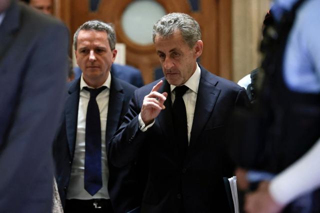 TOPSHOT - France's former President Nicolas Sarkozy gestures during his appeal trial over charges he sought Libyan financing for his 2007 election, at the Palais de Justice courthouse in Paris on April 8, 2026. The Paris Criminal Court in September 2025 convicted Sarkozy of criminal conspiracy and handed him a 5-year prison sentence over what it said was a scheme to acquire funding from Muammar Gaddafi's Libya for his 2007 presidential run that saw him elected. The right-wing politician -- who has denied any wrongdoing -- entered a Paris jail in October 2025, serving 20 days before he was released under judicial supervision. (Photo by STEPHANE DE SAKUTIN / AFP)