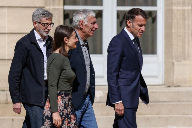 French President Emmanuel Macron (R), flanked by French ambassador to Iran Pierre Cochard (L), welcomes French national Cecile Kohler (C-L) and French National Jacques Paris (C-R) freed by Iran after three and a half years in detention, at the Elysee Palace in Paris, on April 8, 2026. Two French nationals arrived in Paris on April 8, 2026 after spending more than three years in an Iranian prison on espionage charges, with President Emmanuel Macron hailing "the end of a terrible ordeal." (Photo by Tom Nicholson / POOL / AFP)