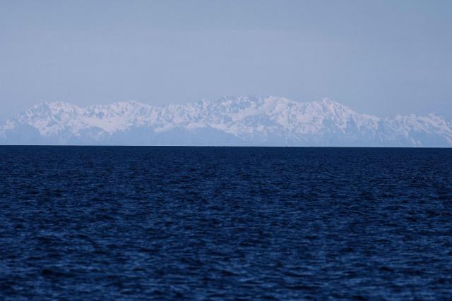 This photograph shows the Corsican mountains as seen from the Mediterranean sea, off the coast of Marseille, on April 7, 2026. (Photo by Thibaud MORITZ / AFP)