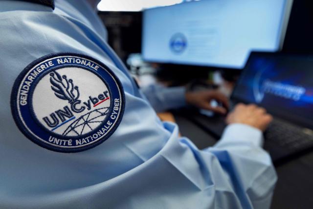 This photograph shows the badge on a uniform of a police officer from the National Cyber Unit (Unite Nationale Cyber, UNCyber) of the National Gendarmerie in Pontoise on April 7, 2026. (Photo by JOEL SAGET / AFP)