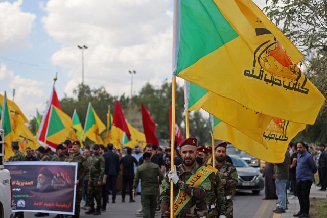 Members of Iraq's pro-Iran paramilitary group Hezbollah Brigades (Kataeb Hezbollah) gather in a mourning procession for one of their comrades who was killed the previous day in a strike in Basra, during the funeral in Baghdad on April 8, 2026. Iraqi armed factions loyal to Iran and operating under the banner of the "Islamic Resistance in Iraq" announced a two-week halt to attacks they had launched since the start of the war in the Middle East against "enemy bases" in Iraq and the region. The announcement came shortly after Washington and Tehran declared a ceasefire for the same period. (Photo by AHMAD AL-RUBAYE / AFP)