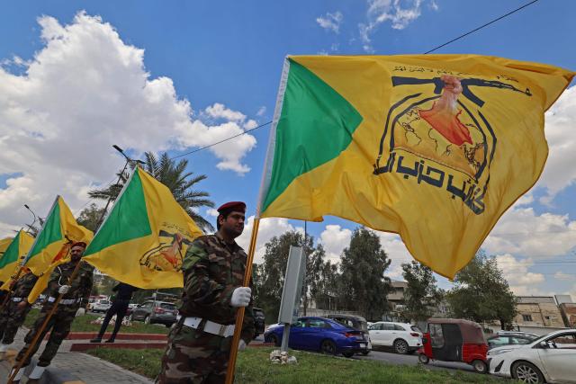Members of Iraq's pro-Iran paramilitary group Hezbollah Brigades (Kataeb Hezbollah) gather in a mourning procession for one of their comrades who was killed the previous day in a strike in Basra, during the funeral in Baghdad on April 8, 2026. Iraqi armed factions loyal to Iran and operating under the banner of the "Islamic Resistance in Iraq" announced a two-week halt to attacks they had launched since the start of the war in the Middle East against "enemy bases" in Iraq and the region. The announcement came shortly after Washington and Tehran declared a ceasefire for the same period. (Photo by AHMAD AL-RUBAYE / AFP)