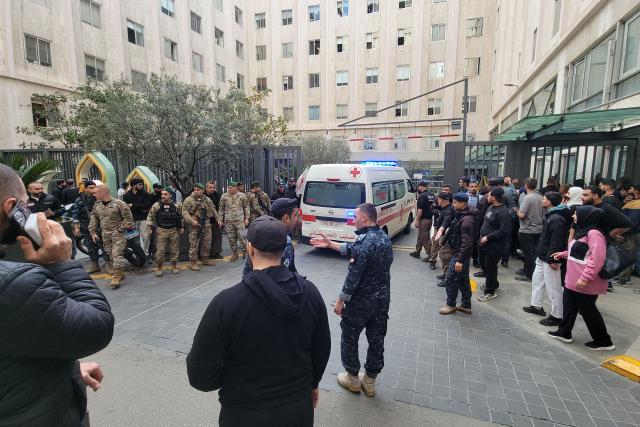 Lebanese security officials stand guard as victims are rushed to a hospital in Beirut following a series of Israeli airstrikes that targeted several areas in the Lebanese capital and its outskirts on April 8, 2026. Israel launched a series of strikes in Beirut, causing panic among residents in the most violent attack on the capital since the start of the war with Hezbollah. Israel also hit Beirut's southern suburbs and southern Lebanon, where Hezbollah holds sway, in parallel with strikes on the east. Israel has insisted the two-week truce in its war with Iran does not apply to Lebanon. (Photo by Fadel ITANI / AFP)