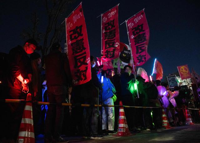 Protesters hold up anti-war placards during a demonstration by opposition political groups and activists across the street from the Diet, Japan’s House of Representatives, in central Tokyo, on April 8, 2026 to oppose revisions to the Constitution and protest attacks by the United States and Israel on Iran. (Photo by Andrew CABALLERO-REYNOLDS / AFP)