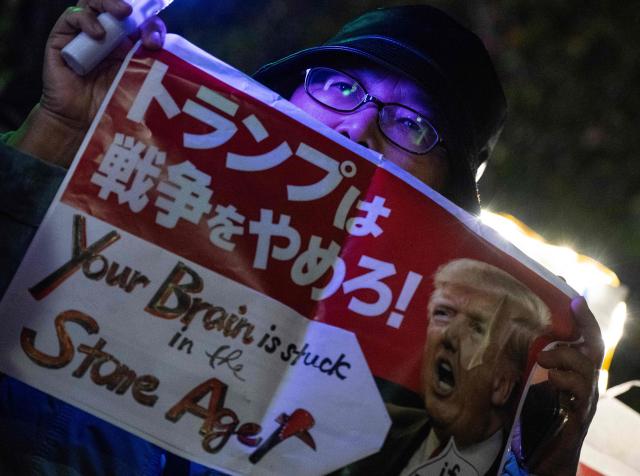 A protester holds a poster opposing US President Donald Trump during a demonstration by opposition political groups and activists across the street from the Diet, Japan’s House of Representatives, in central Tokyo on April 8, 2026 to oppose revisions to the Constitution and to protest attacks by the United States and Israel on Iran. (Photo by Andrew CABALLERO-REYNOLDS / AFP)