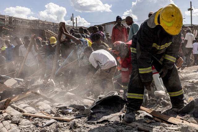 A member of the Nairobi city county fire and rescue department, search through the rubbles after a building collapsed, killing three people and injuring several others, at the Nyayo high-rise, Soweto village in Kibera, Nairobi on April 8, 2026. (Photo by SIMON MAINA / AFP)