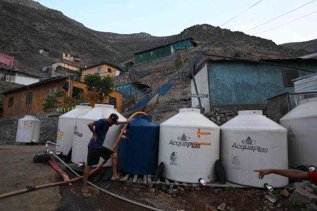 A man fills water tanks from a tanker truck as part of a water supply operation in the Villa Maria del Triunfo neighborhood in Lima, on April 8, 2026. Peruvians will choose from a bewildering array of 35 presidential candidates on April 12, 2026, electing the next leader of an Andean nation beset by crime and a string of short-lived, scandal tainted presidencies. (Photo by Luis ROBAYO / AFP)