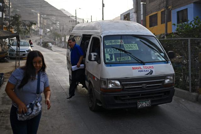 A man gets off a public transportation van in the Villa Maria del Triunfo neighborhood in Lima, on April 8, 2026. Peruvians will choose from a bewildering array of 35 presidential candidates on April 12, 2026, electing the next leader of an Andean nation beset by crime and a string of short-lived, scandal tainted presidencies. (Photo by Luis ROBAYO / AFP)