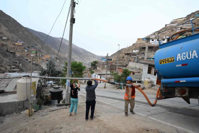 People fill water tanks from a tanker truck as part of a water supply operation in the Villa Maria del Triunfo neighborhood in Lima, on April 8, 2026. Peruvians will choose from a bewildering array of 35 presidential candidates on April 12, 2026, electing the next leader of an Andean nation beset by crime and a string of short-lived, scandal tainted presidencies. (Photo by Luis ROBAYO / AFP)