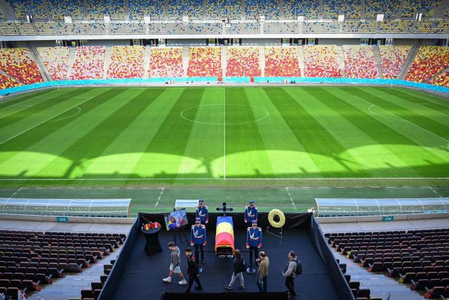 Honor guard soldiers stand next to the coffin of Romanian football legend Mircea Lucescu as it is laid in state at the National Arena in Bucharest, Romania, April 8, 2026. Fans and figures from the sporting world gathered at the country's largest stadium to pay their final respects to the former national team coach and one of the most decorated managers in history, who passed away on April 7, 2026, at the age of 80. (Photo by Daniel MIHAILESCU / AFP)