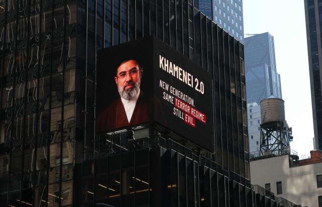 An image of Mojtaba Khamenei, who was appointed as the new Supreme Leader of Iran following the death of his father, Ali Khamenei is displayed in Times Square in New York on April 8, 2026. Israel’s Foreign Ministry shared a video showing a stark message aimed at Iran’s new leadership: “Khamenei 2.0: New generation, same terror regime, still evil.” (Photo by TIMOTHY A. CLARY / AFP)