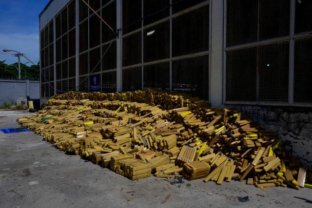View of 48 tons of seized marijuana and weapons presented at the City of Police in Rio de Janeiro, Brazil on April 8, 2026, after they were uncovered by chance by a sniffer dog during a regular operation against criminal factions. During the operation in the Complexo da Mare, a large complex of favelas in the north of the city, a dog named Hulk indicated there was something suspicious under an abandoned water tank. An officer "discovered a bunker inside where this entire quantity of drugs had been hidden," said Lieutenant Colonel Luciano Pedro, commander of the Canine Operations Battalion. (Photo by Pablo PORCIUNCULA / AFP)