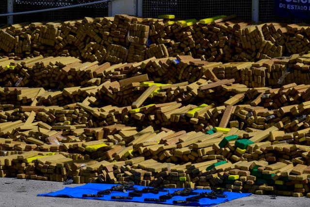 View of 48 tons of seized marijuana and weapons presented at the City of Police in Rio de Janeiro, Brazil on April 8, 2026, after they were uncovered by chance by a sniffer dog during a regular operation against criminal factions. During the operation in the Complexo da Mare, a large complex of favelas in the north of the city, a dog named Hulk indicated there was something suspicious under an abandoned water tank. An officer "discovered a bunker inside where this entire quantity of drugs had been hidden," said Lieutenant Colonel Luciano Pedro, commander of the Canine Operations Battalion. (Photo by Pablo PORCIUNCULA / AFP)