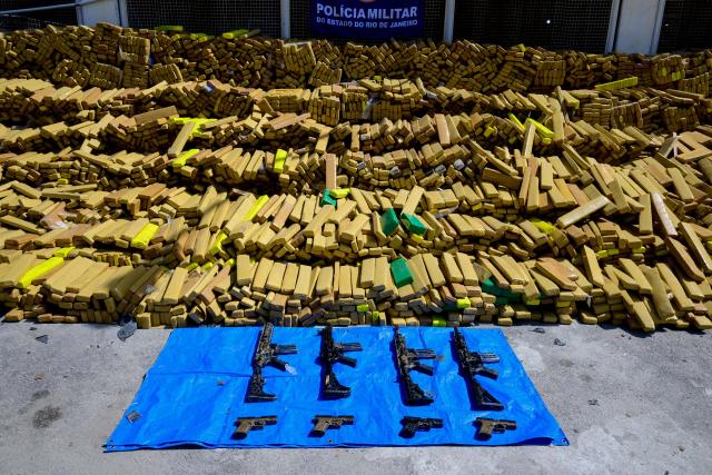 View of 48 tons of seized marijuana and weapons presented at the City of Police in Rio de Janeiro, Brazil on April 8, 2026, after they were uncovered by chance by a sniffer dog during a regular operation against criminal factions. During the operation in the Complexo da Mare, a large complex of favelas in the north of the city, a dog named Hulk indicated there was something suspicious under an abandoned water tank. An officer "discovered a bunker inside where this entire quantity of drugs had been hidden," said Lieutenant Colonel Luciano Pedro, commander of the Canine Operations Battalion. (Photo by Pablo PORCIUNCULA / AFP)