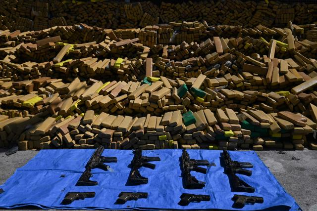 View of 48 tons of seized marijuana and weapons presented at the City of Police in Rio de Janeiro, Brazil on April 8, 2026, after they were uncovered by chance by a sniffer dog during a regular operation against criminal factions. During the operation in the Complexo da Mare, a large complex of favelas in the north of the city, a dog named Hulk indicated there was something suspicious under an abandoned water tank. An officer "discovered a bunker inside where this entire quantity of drugs had been hidden," said Lieutenant Colonel Luciano Pedro, commander of the Canine Operations Battalion. (Photo by Pablo PORCIUNCULA / AFP)