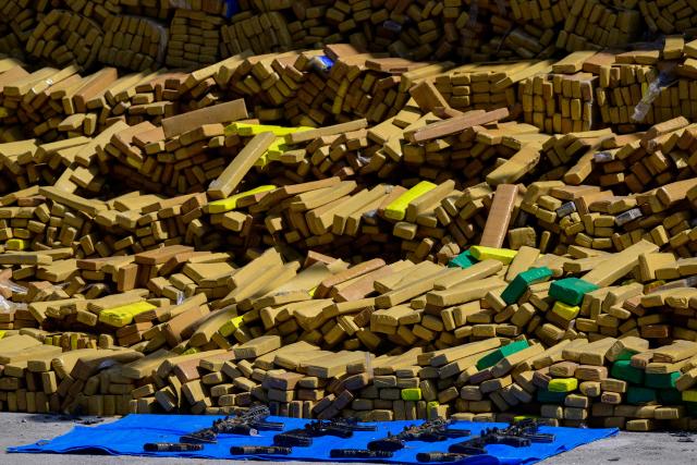 View of 48 tons of seized marijuana and weapons presented at the City of Police in Rio de Janeiro, Brazil on April 8, 2026, after they were uncovered by chance by a sniffer dog during a regular operation against criminal factions. During the operation in the Complexo da Mare, a large complex of favelas in the north of the city, a dog named Hulk indicated there was something suspicious under an abandoned water tank. An officer "discovered a bunker inside where this entire quantity of drugs had been hidden," said Lieutenant Colonel Luciano Pedro, commander of the Canine Operations Battalion. (Photo by Pablo PORCIUNCULA / AFP)