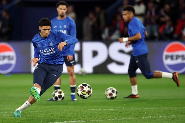 Morocco's defender #02 Achraf Hakimi (L) warms up ahead of the UEFA Champions League quarter-final first leg football match between Paris Saint-Germain (PSG) and Liverpool FC at the Parc des Princes stadium in Paris on April 8, 2026. (Photo by Anne-Christine POUJOULAT / AFP)