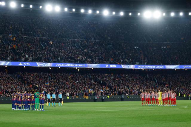 Barcelona and Atletico Madrid players observe a moment of silence in memory of legendary coach Mircea Lucescu before the UEFA Champions League quarter final first leg football match between FC Barcelona and Club Atletico de Madrid at Camp Nou Stadium in Barcelona on April 8, 2026. (Photo by Lluis GENE / AFP)