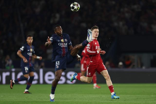 Paris Saint-Germain's Ecuadorian defender #51 Willian Pacho (L) fights for the ball with Liverpool's German midfielder #07 Florian Wirtz during the UEFA Champions League quarter-final first leg football match between Paris Saint-Germain (PSG) and Liverpool FC at the Parc des Princes stadium in Paris on April 8, 2026. (Photo by Anne-Christine POUJOULAT / AFP)