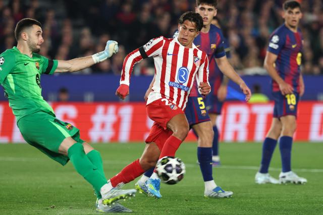 Barcelona's Spanish goalkeeper #13 Joan Garcia (L) kicks the ball challenged by Atletico Madrid's Argentine forward #20 Giuliano Simeone during the UEFA Champions League quarter final first leg football match between FC Barcelona and Club Atletico de Madrid at Camp Nou Stadium in Barcelona on April 8, 2026. (Photo by Lluis GENE / AFP)