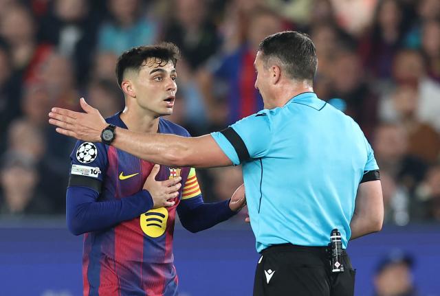 Barcelona's Spanish midfielder #08 Pedri talks with Romanian referee Istvan Kovacs during the UEFA Champions League quarter final first leg football match between FC Barcelona and Club Atletico de Madrid at Camp Nou Stadium in Barcelona on April 8, 2026. (Photo by Josep LAGO / AFP)