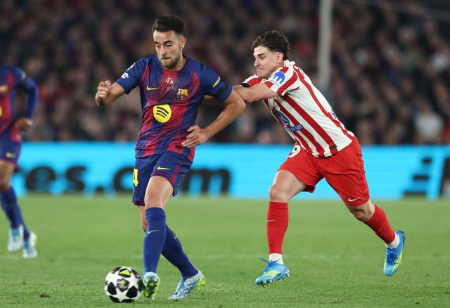 Barcelona's Spanish defender #24 Eric Garcia fights for the ball with Atletico Madrid's Argentine forward #19 Julian Alvarez during the UEFA Champions League quarter final first leg football match between FC Barcelona and Club Atletico de Madrid at Camp Nou Stadium in Barcelona on April 8, 2026. (Photo by Josep LAGO / AFP)