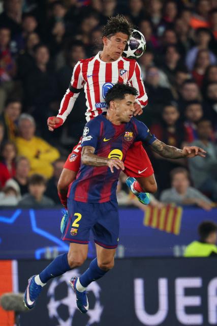 Atletico Madrid's Argentine forward #20 Giuliano Simeone (top) heads the ball challenged by Barcelona's Portuguese defender #02 Joao Cancelo during the UEFA Champions League quarter final first leg football match between FC Barcelona and Club Atletico de Madrid at Camp Nou Stadium in Barcelona on April 8, 2026. (Photo by Lluis GENE / AFP)