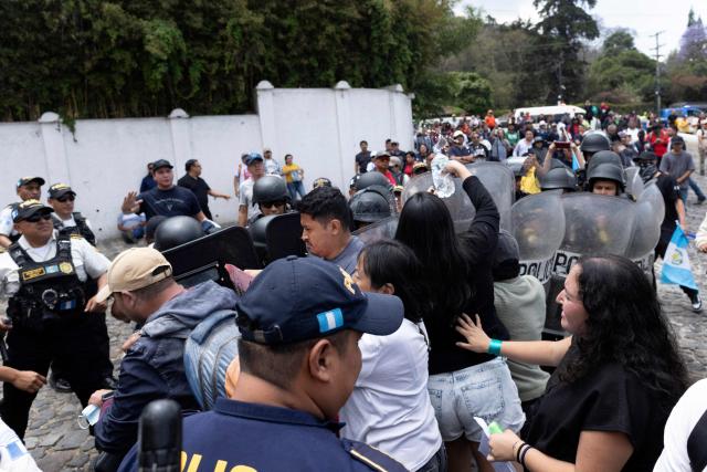 Protesters denouncing an allegedly illegal election clash with riot police outside the venue where authorities of the public University of San Carlos meet to appoint their rector, in Antigua, Guatemala, on April 8, 2026. The reelection of the rector of Guatemala's sole public university ended in gunfire and unrest outside a luxury hotel where the vote was held, which the OAS described as a "tainted process." (Photo by Christian Gutierrez / AFP)