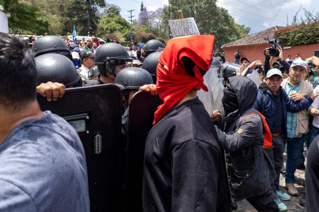 Protesters denouncing an allegedly illegal election clash with riot police outside the venue where authorities of the public University of San Carlos meet to appoint their rector, in Antigua, Guatemala, on April 8, 2026. The reelection of the rector of Guatemala's sole public university ended in gunfire and unrest outside a luxury hotel where the vote was held, which the OAS described as a "tainted process." (Photo by Christian Gutierrez / AFP)
