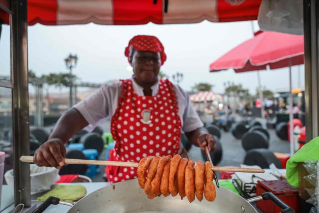 A street vendor prepares 'picarones', a traditional Peruvian dessert of crispy fried rings made from sweet potato and squash dough, at the Alameda Chabuca Granda, in Lima, on April 7, 2026.. (Photo by Connie FRANCE / AFP)