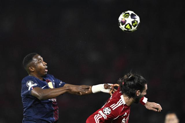 Paris Saint-Germain's Ecuadorian defender #51 Willian Pacho (L) fights for the ball with Liverpool's Hungarian midfielder #08 Dominik Szoboszlai during the UEFA Champions League quarter-final first leg football match between Paris Saint-Germain (PSG) and Liverpool FC at the Parc des Princes stadium in Paris on April 8, 2026. (Photo by JULIEN DE ROSA / AFP)