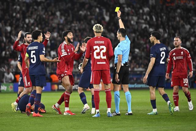 Spanish referee Jose Maria Sanchez (3rdR) shows a yellow card to Liverpool's English defender #02 Joe Gomez (3rdL) during the UEFA Champions League quarter-final first leg football match between Paris Saint-Germain (PSG) and Liverpool FC at the Parc des Princes stadium in Paris on April 8, 2026. (Photo by JULIEN DE ROSA / AFP)