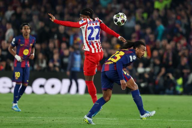 Atletico Madrid's English forward #22 Ademola Lookman (C) vies for the ball with Barcelona's French defender #23 Jules Kounde during the UEFA Champions League quarter final first leg football match between FC Barcelona and Club Atletico de Madrid at Camp Nou Stadium in Barcelona on April 8, 2026. (Photo by Lluis GENE / AFP)